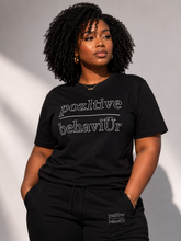 Load image into Gallery viewer, Person wearing a black t-shirt with 'pozltive behaviUr' text against a neutral background